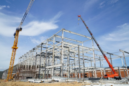 steel building structure with cranes lifitng steel bars